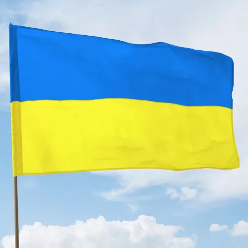 Flaga ukraińska na drzewcu na tle nieba